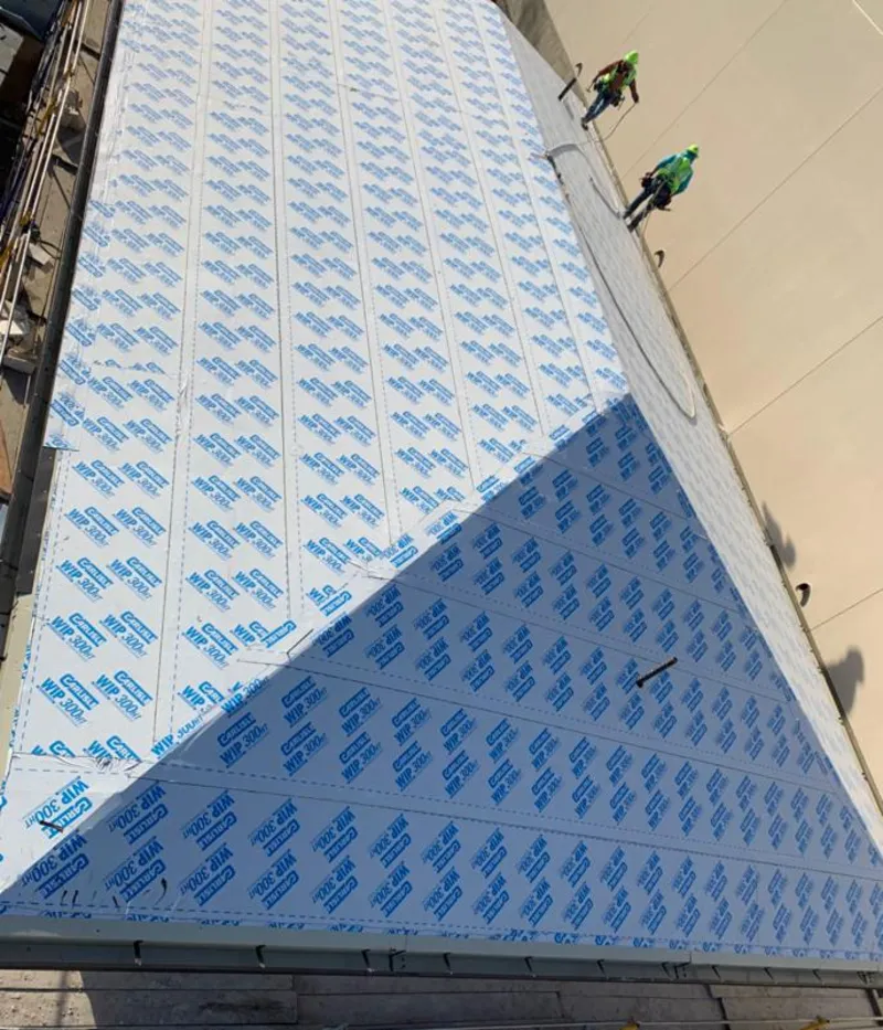 Professional roofers installing underlayment on a metal roof in Syracuse